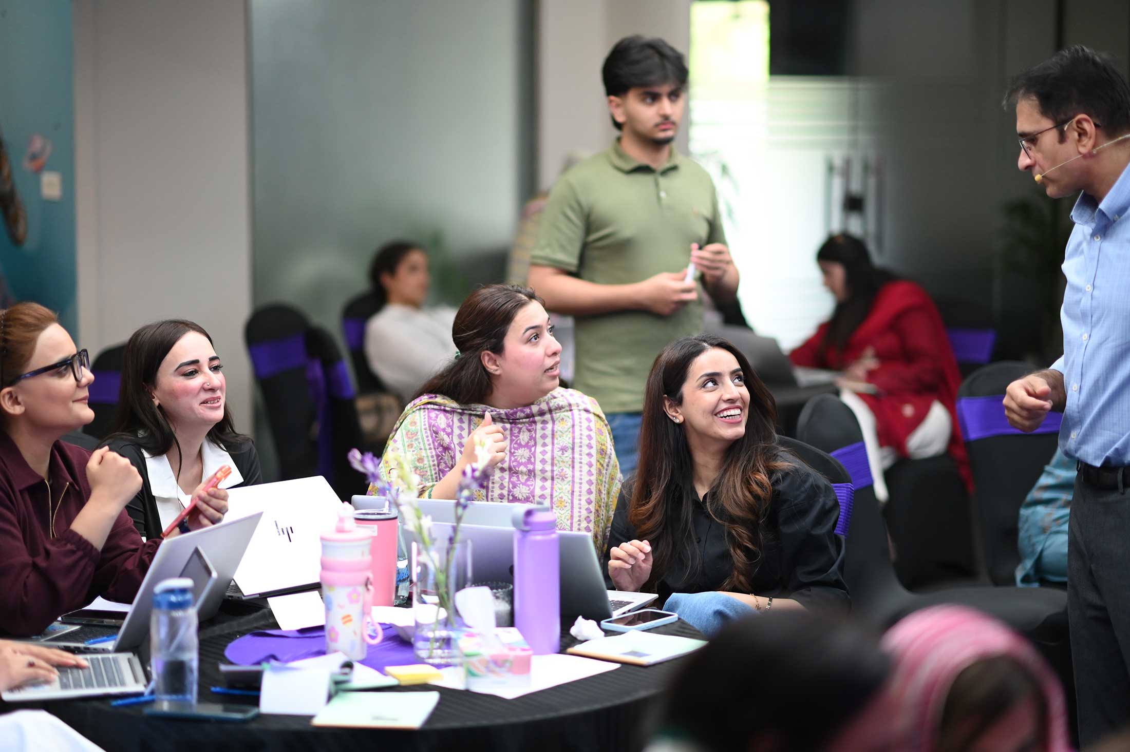MMBL senior women leaders laughing and engaged with Think FRST trainer during AI adoption workshop.