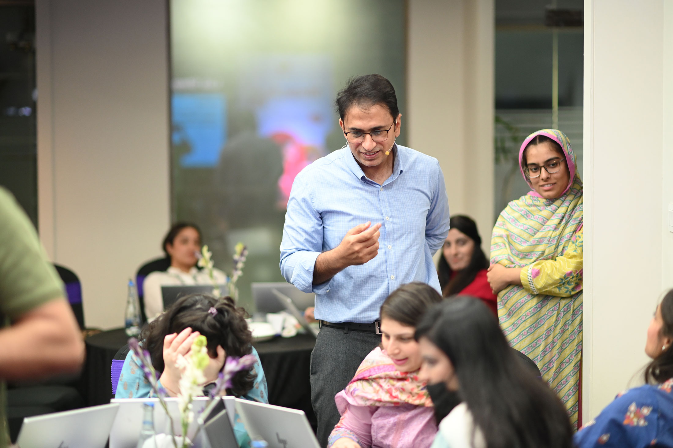 Think FRST trainer coaching MMBL senior leaders hands-on with AI during the workshop.