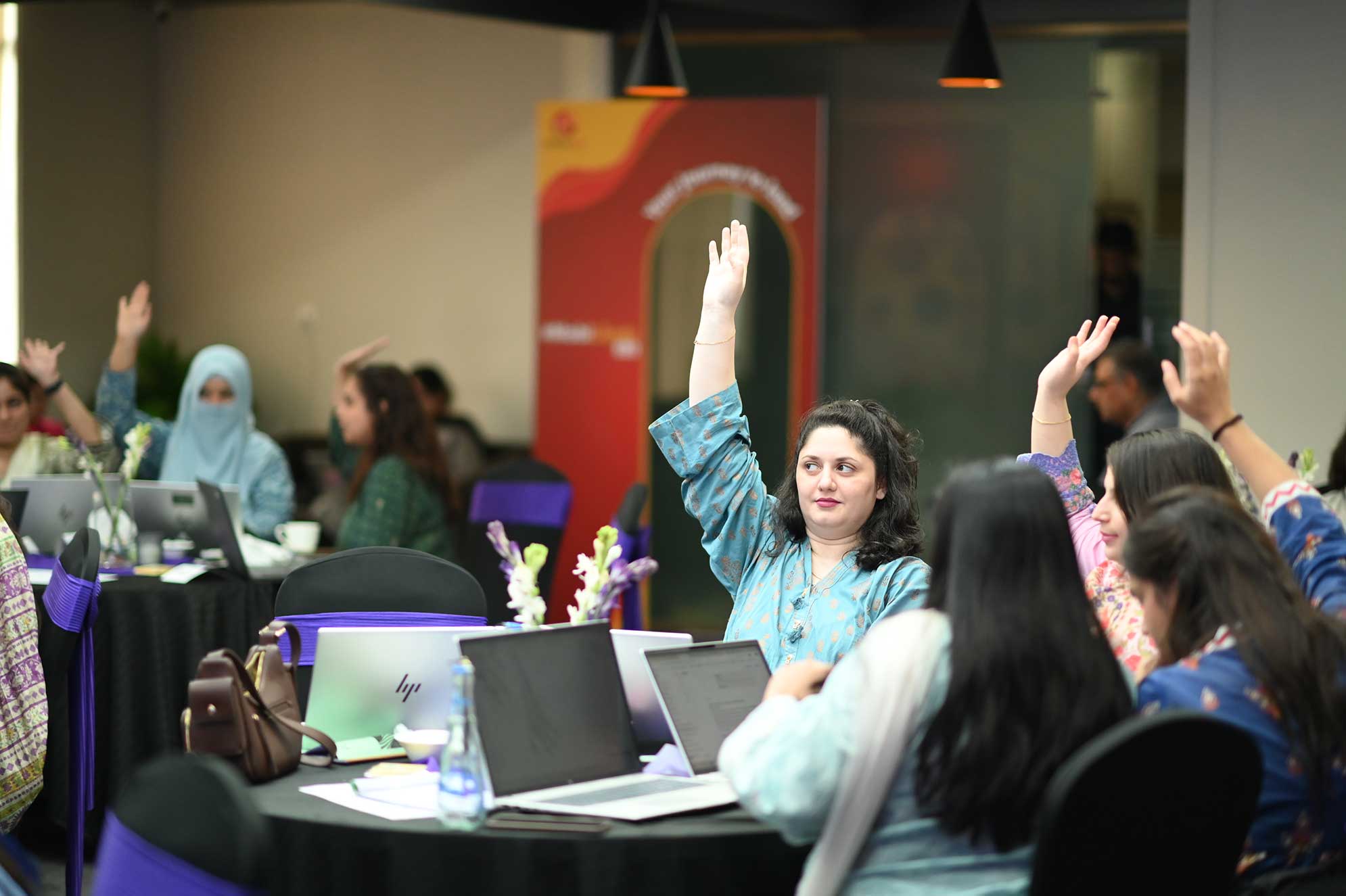 MMBL senior leaders raising hands during Think FRST AI adoption workshop.